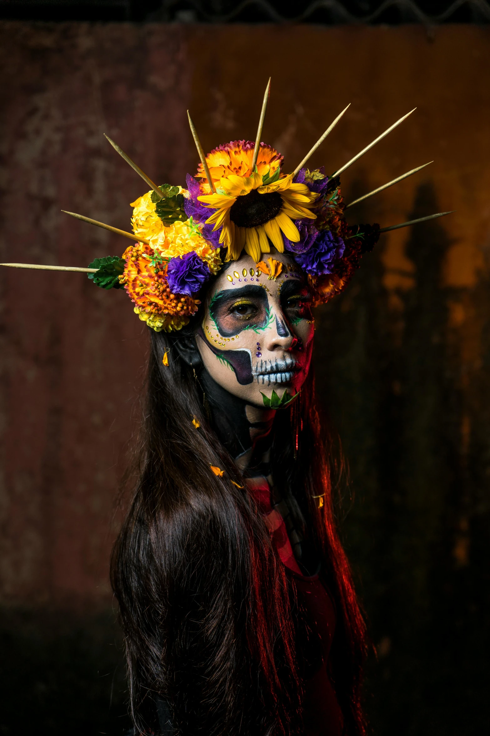 a woman with dark makeup and flowers painted on her face