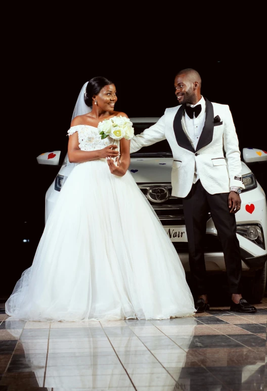 the bride and groom are posing for pos in front of their wedding car