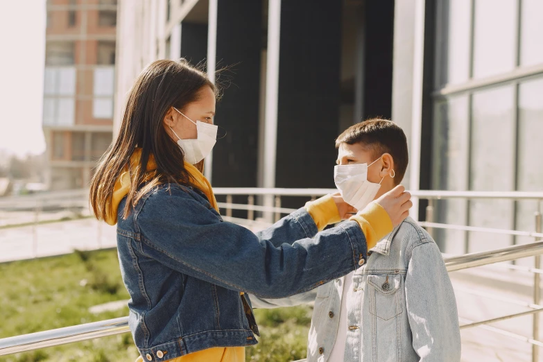 woman wearing a protective mask looking at a man on his arm