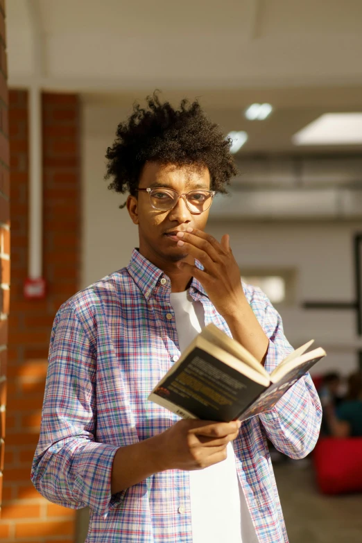 a young man reading while looking at his book