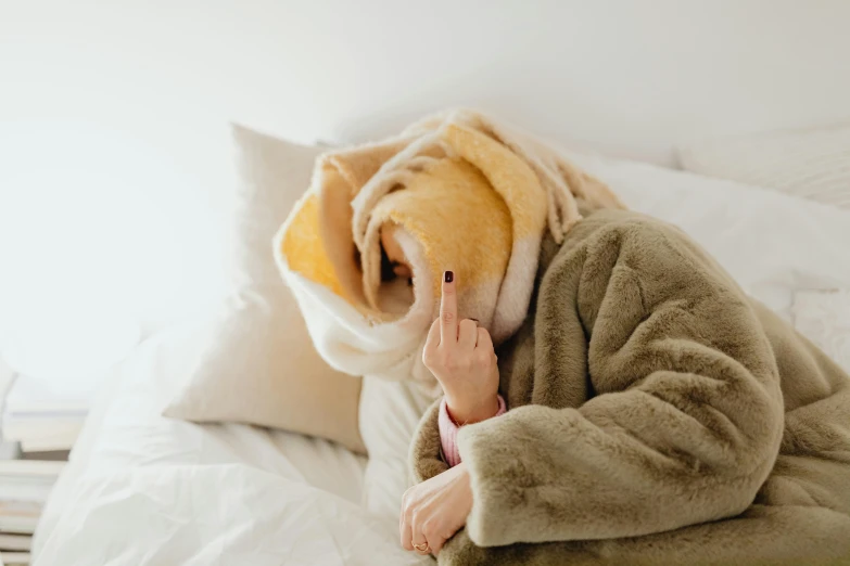 a woman covering her face with a blanket