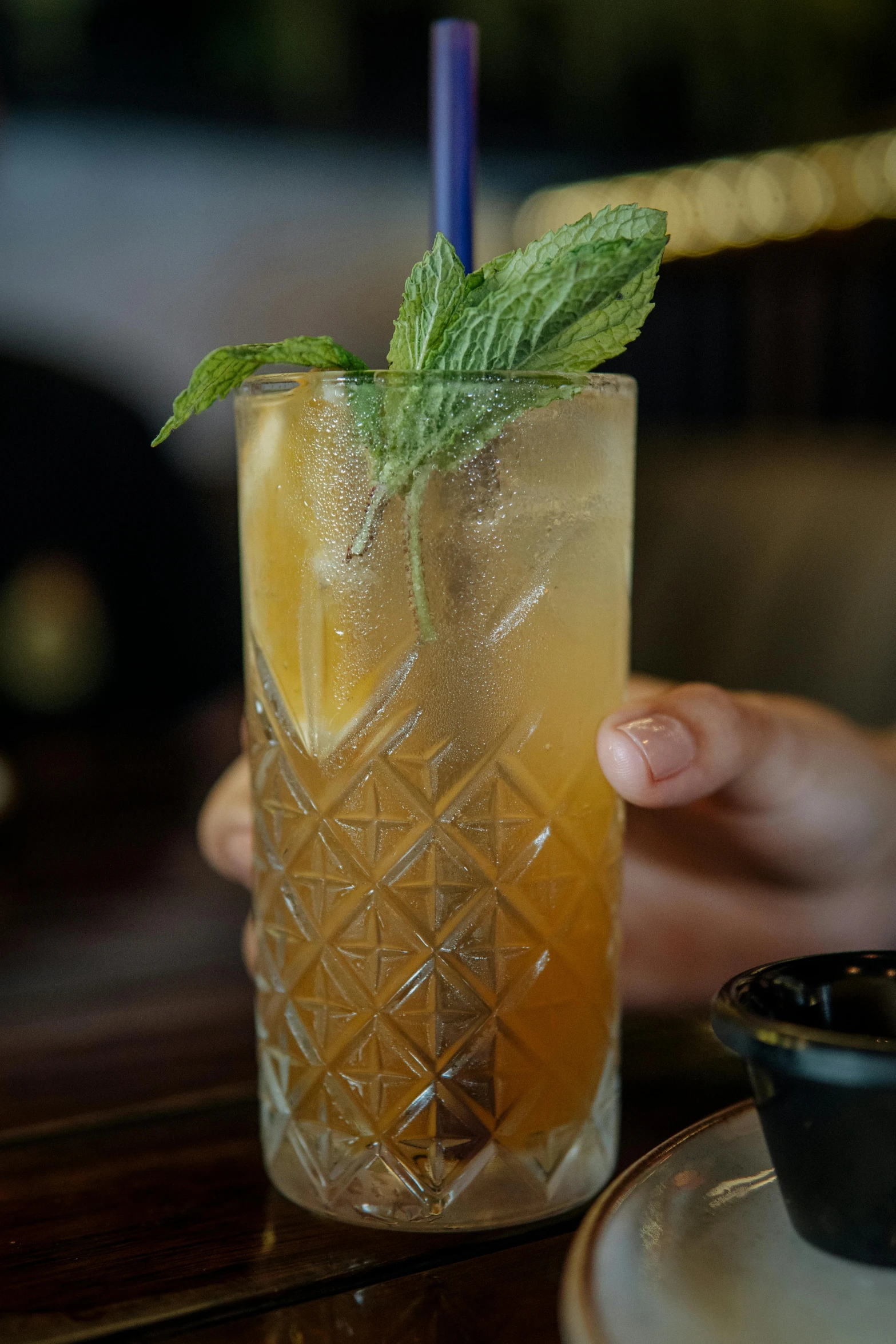 a person holding a tall glass with drinks in it