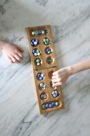 the wooden tray is filled with colored glass pebbles