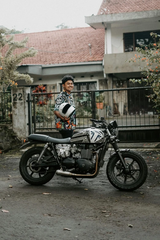 the person stands next to a motorcycle outside