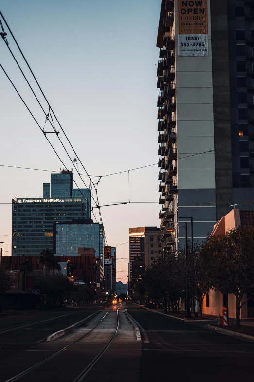 a street with cars, stoplights and buildings in the background