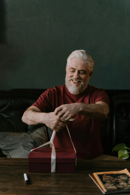 a man sitting at a table opening his shoe box