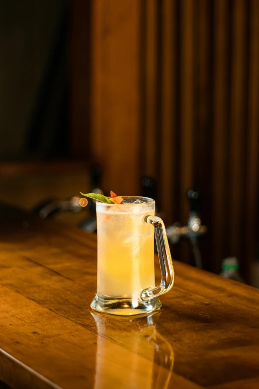 a pitcher of liquid sitting on a wooden table