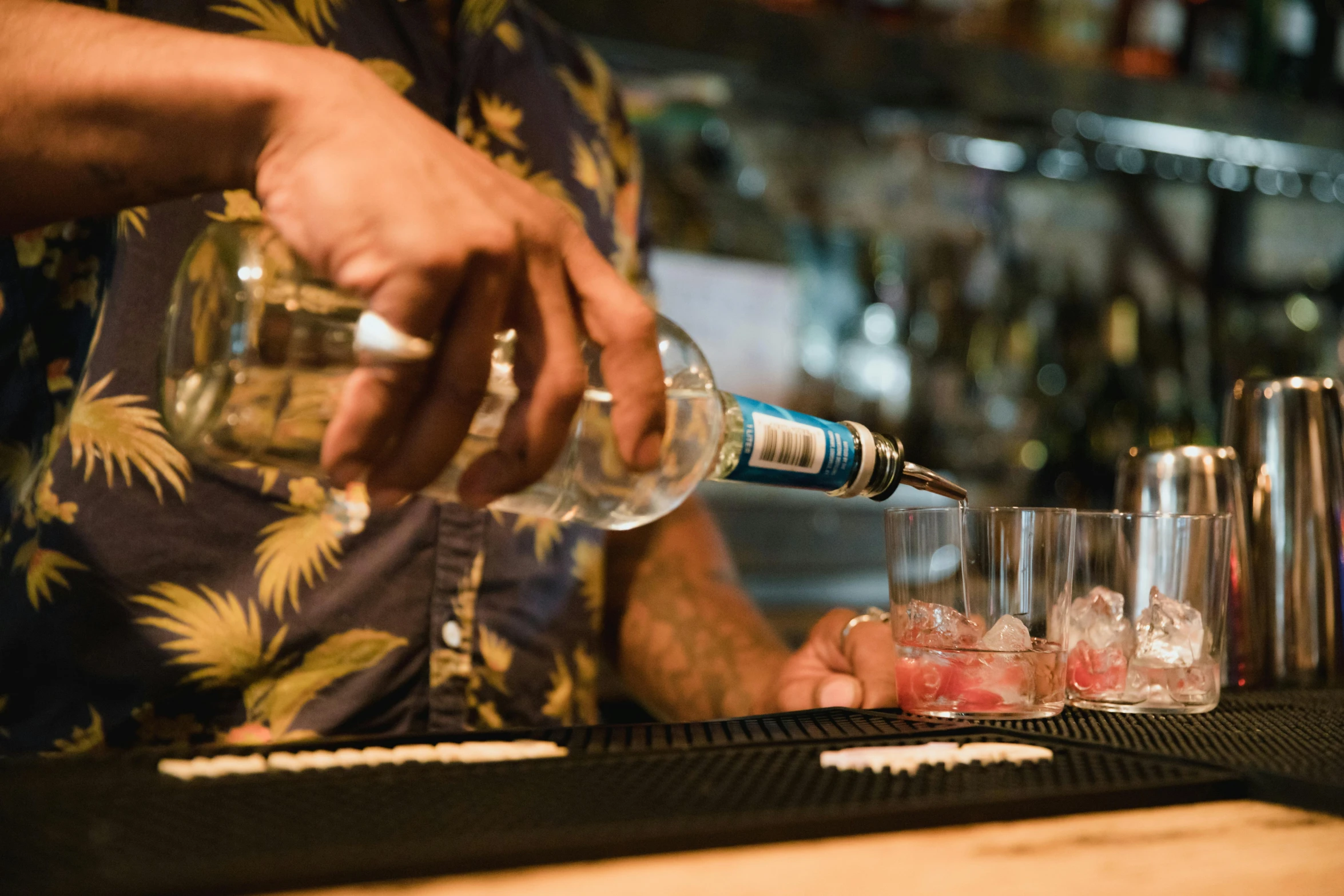 a bartender is pouring some drinks on a bar