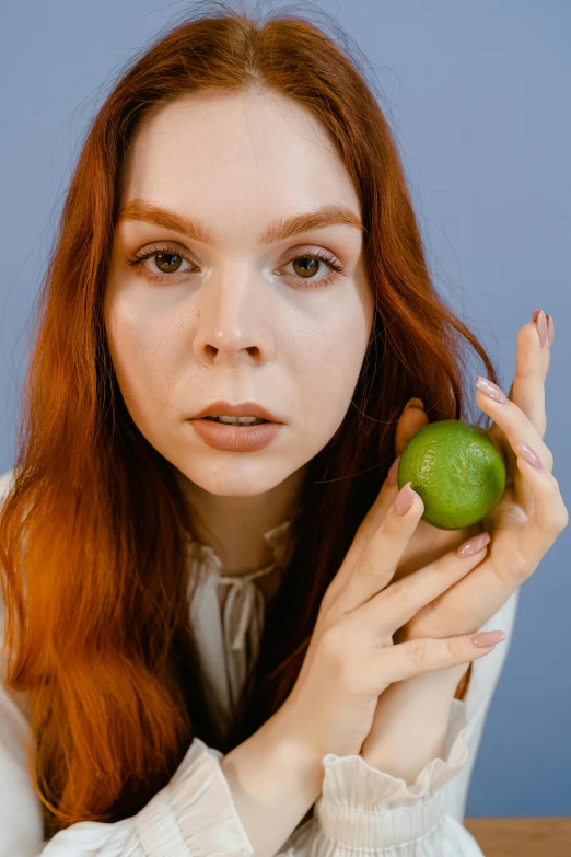 a young woman with a green apple on a table