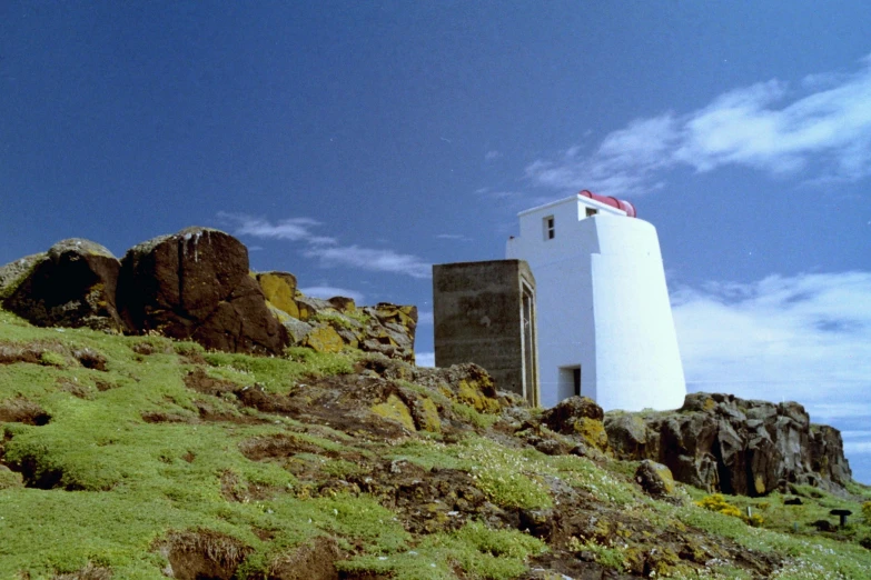 an empty building sitting on a hill next to some rocky