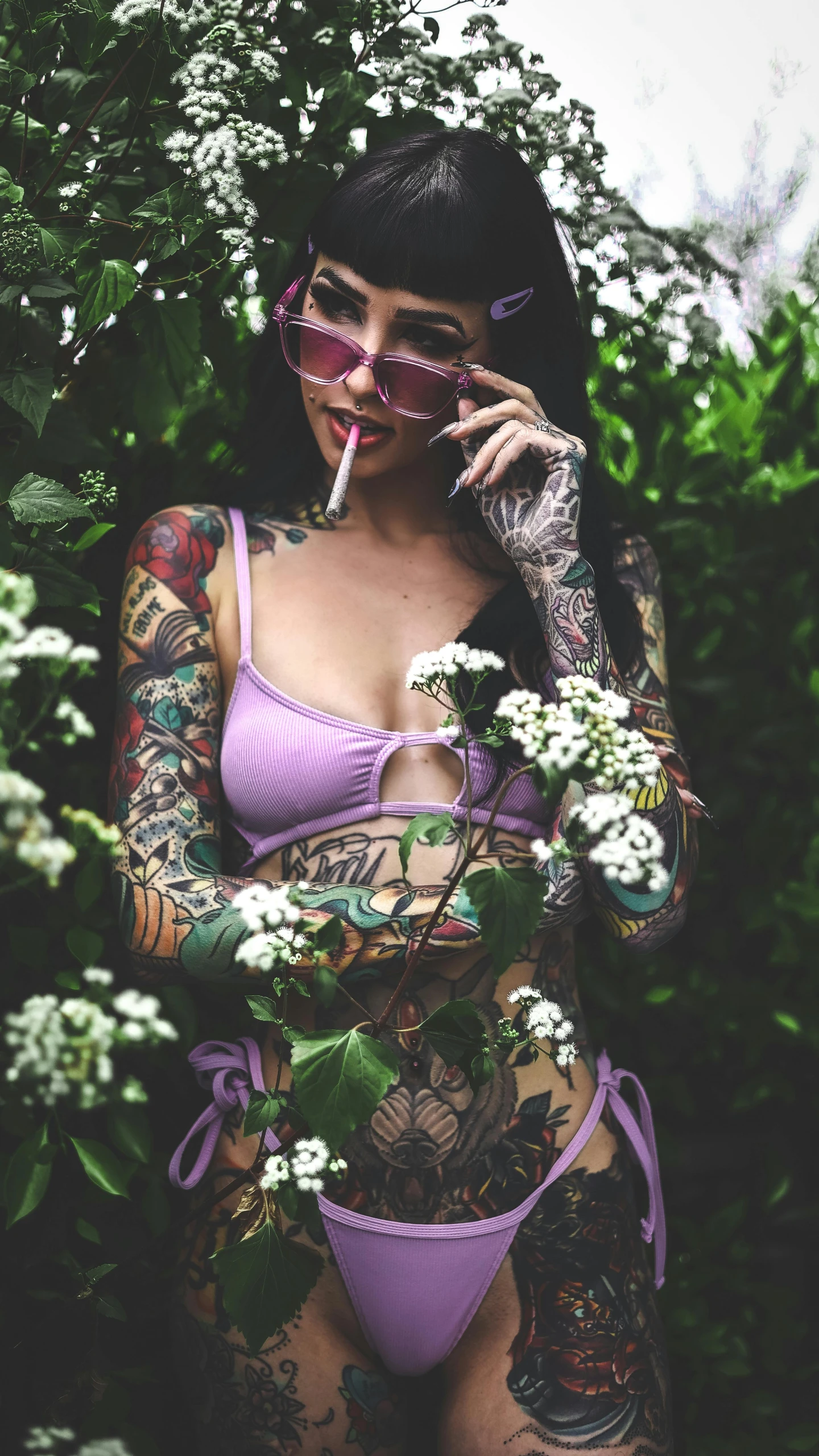 woman in lavender outfit holding cigarette and smoking weed