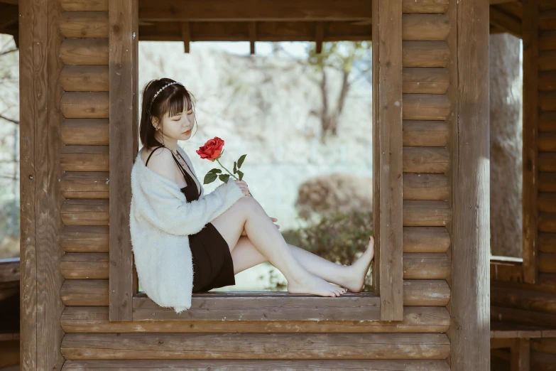 a woman in white sweater sitting on wooden porch