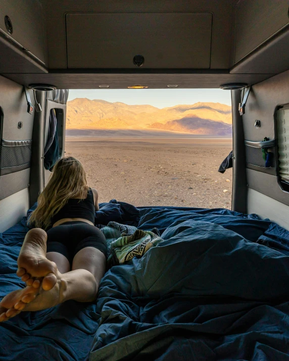 a girl lays in her truck with an extra mattress