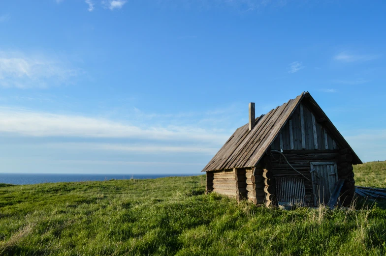 a small wooden house sitting in a field