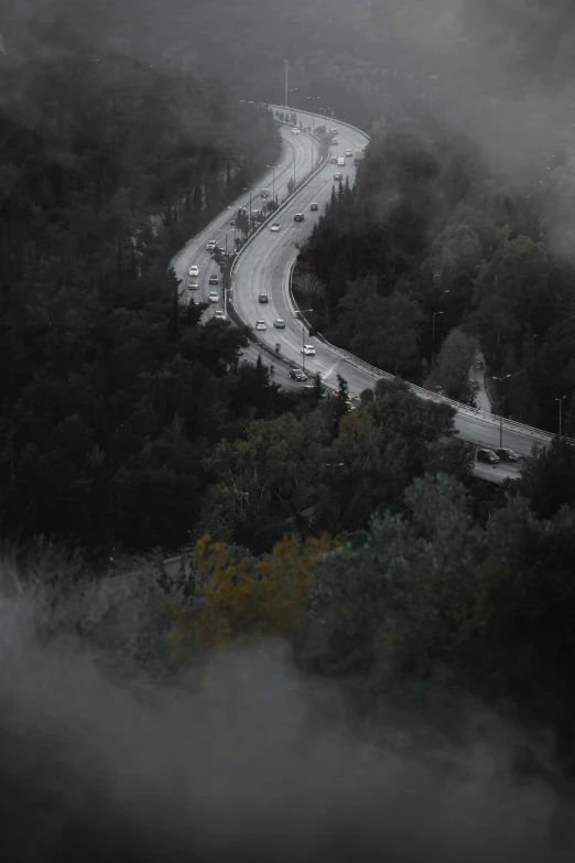 the cars are driving down the mountain side road