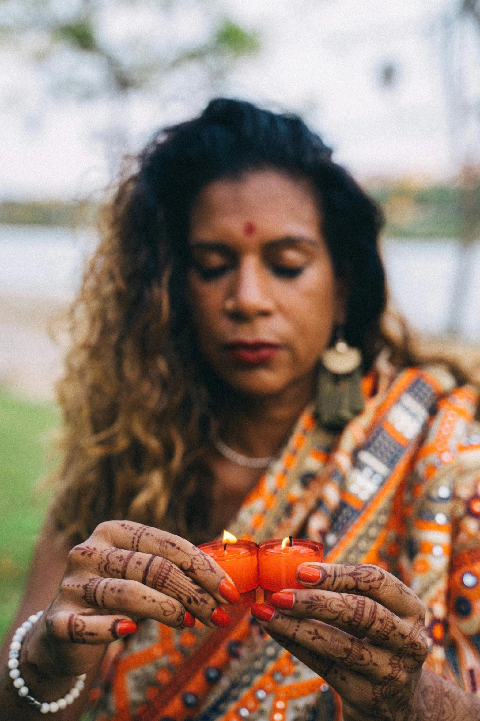 a woman holding a lit orange on top of her hand