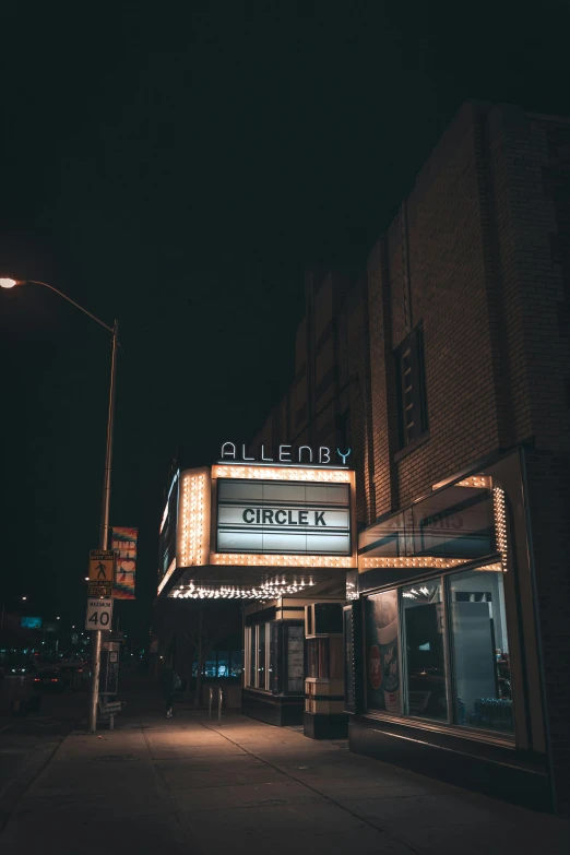 a theater called ciner by some buildings at night