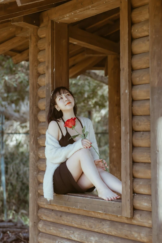 a woman is sitting on a wood cabin