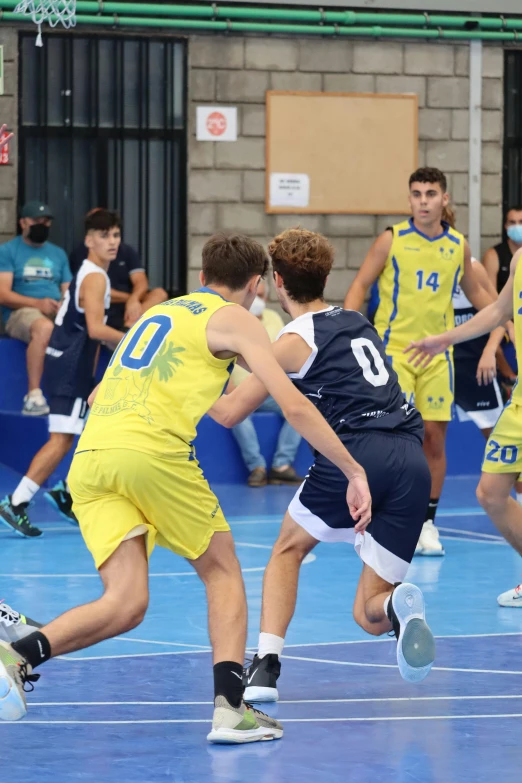 men in sports uniforms during a game in a gym