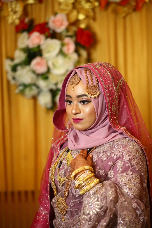 a woman in a pink dress is holding a necklace