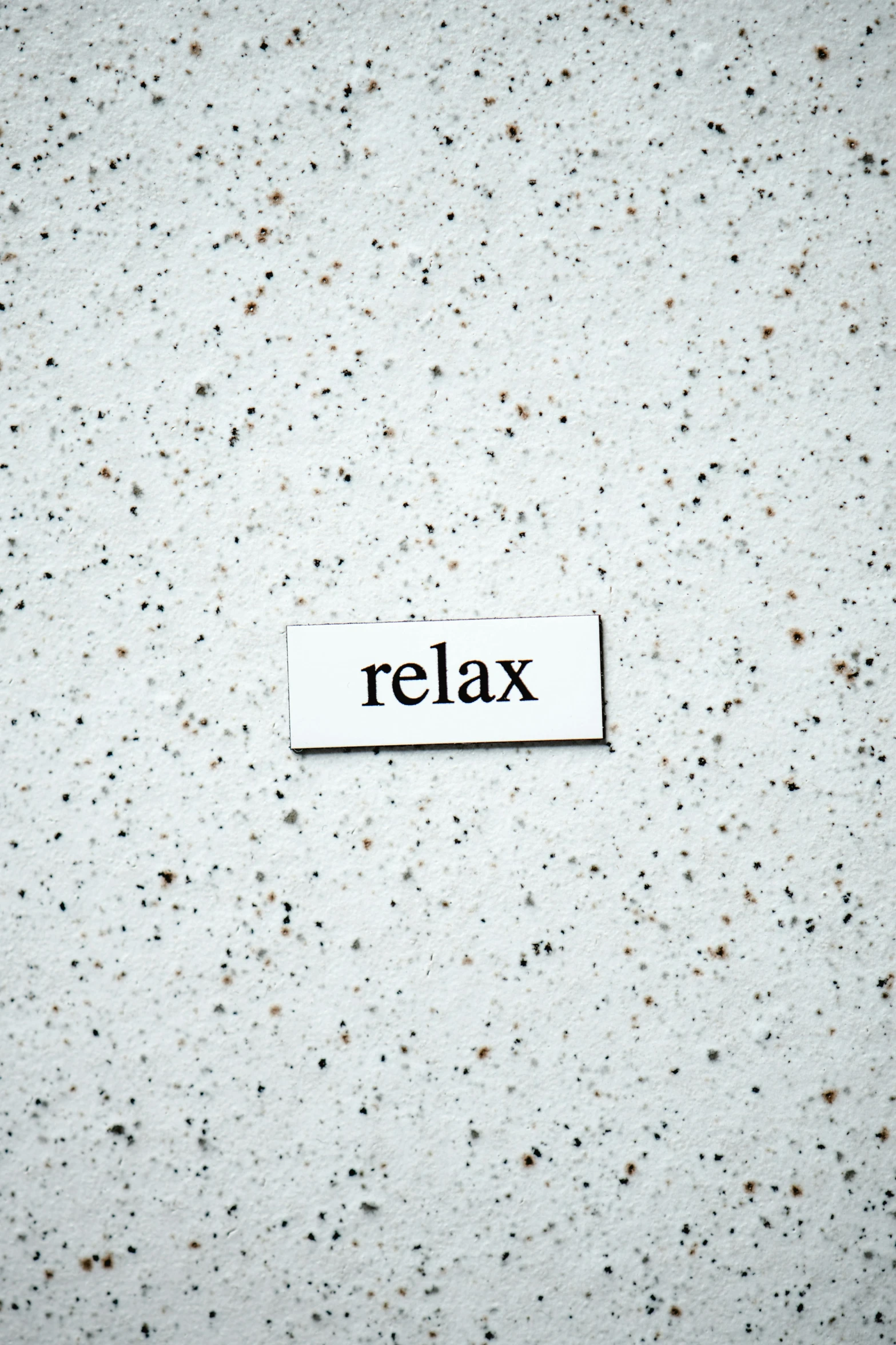 the word relax written on white paper with holes on it