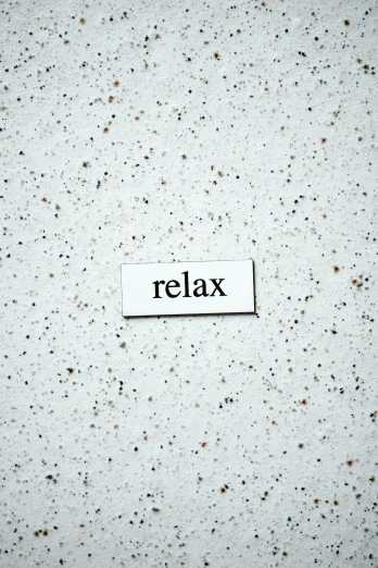 the word relax written on white paper with holes on it
