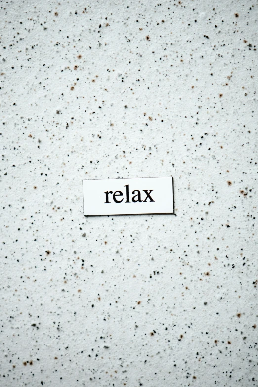 the word relax written on white paper with holes on it