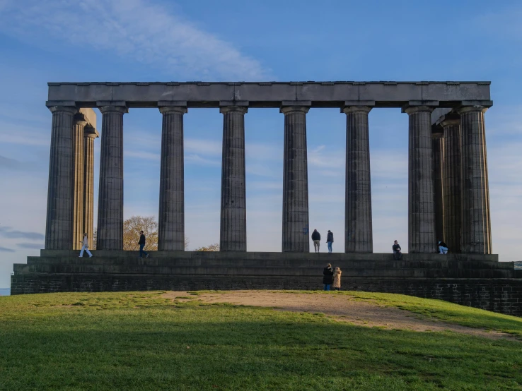 four people stand around large stone pillars