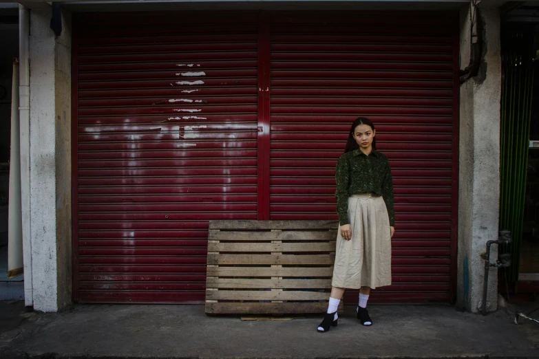 the woman is posing for a po with a wooden crate