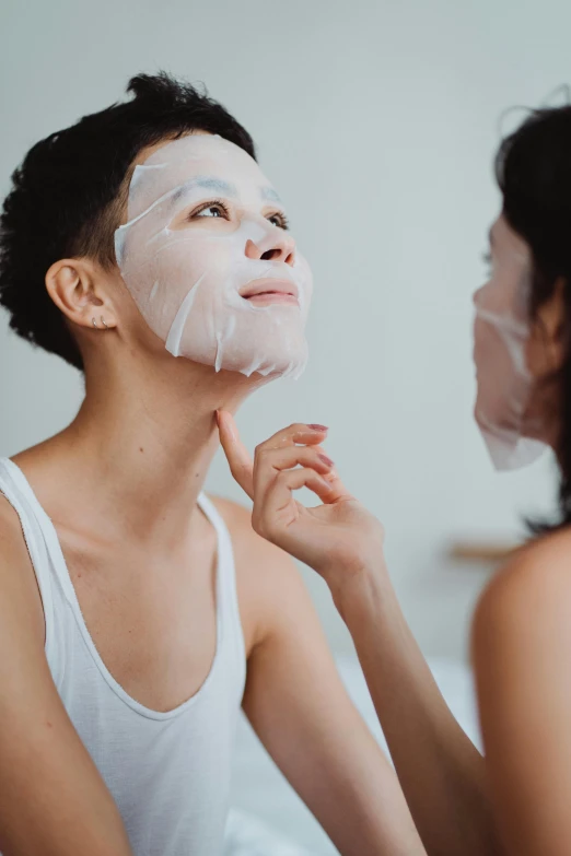 a woman is seen using a mask on her face