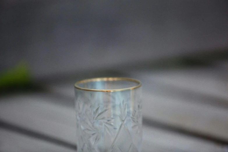 an antique looking clear cup is on a table