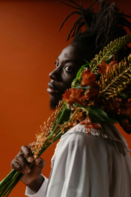 a man with flowers on his head holding flowers