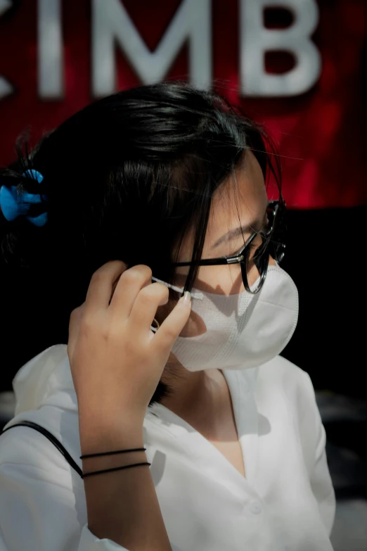 a woman with glasses holds her nose to her nose