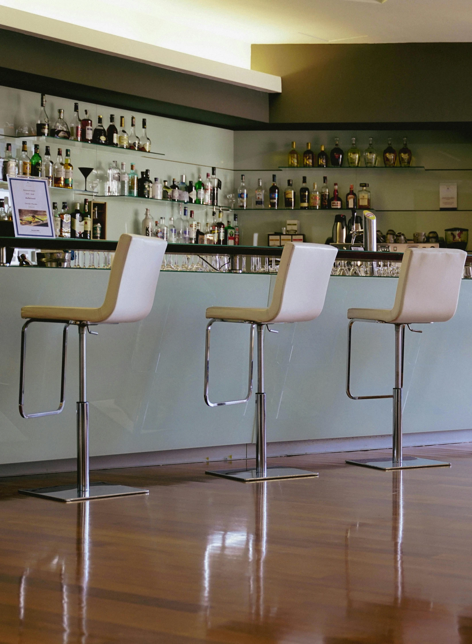 four white chairs sit at a bar behind them