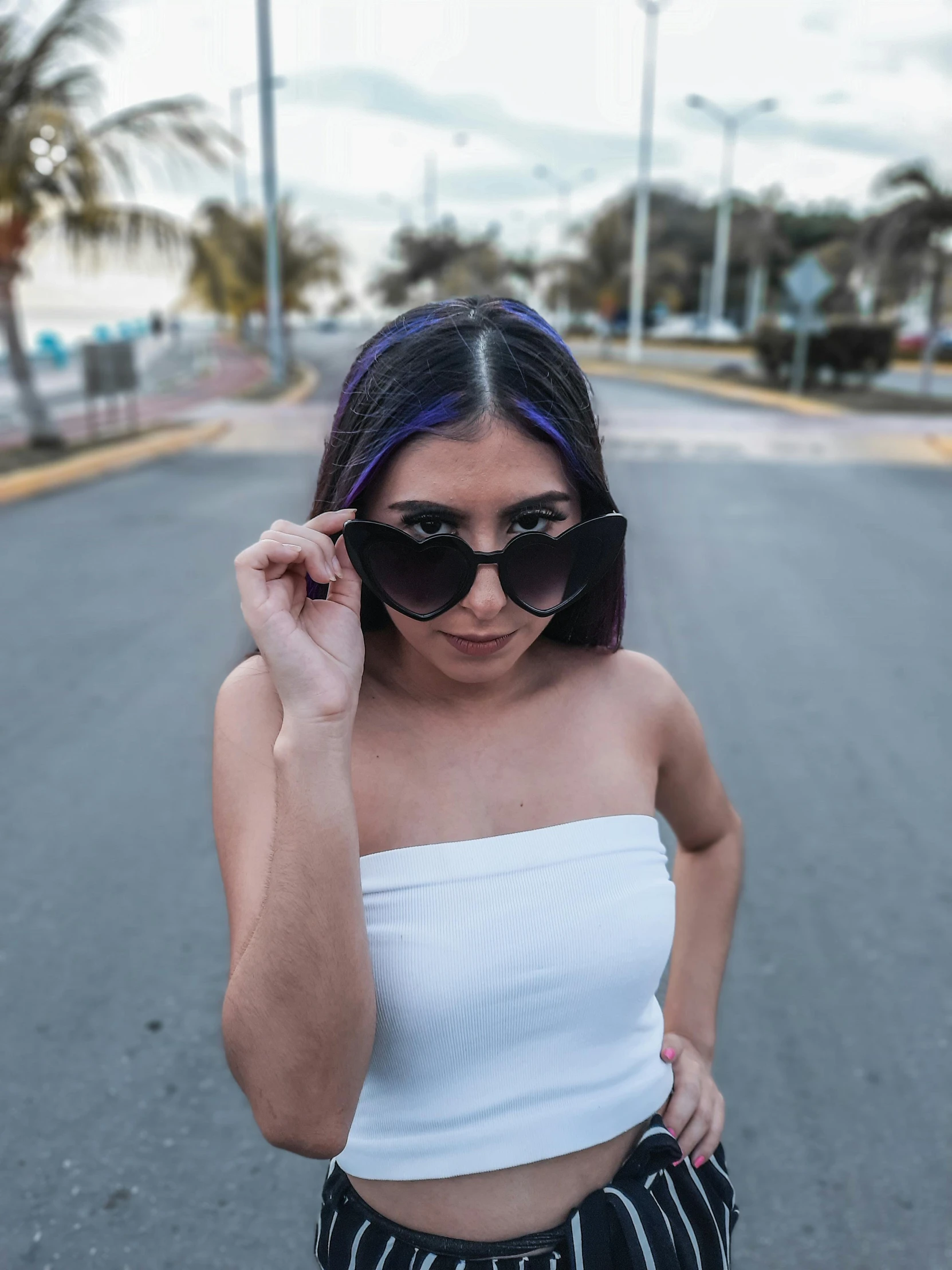 a woman with blue hair wearing sunglasses