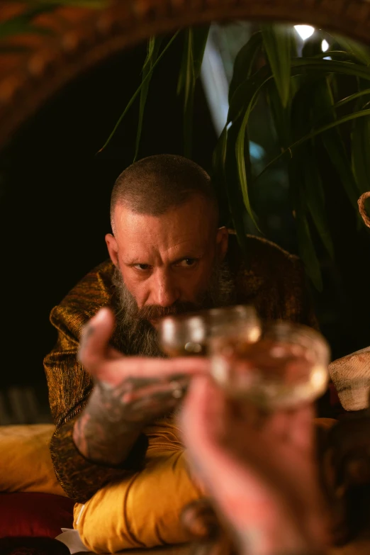 a man that is sitting down with a glass in his hands