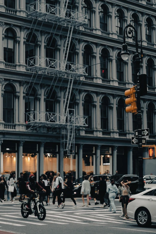 a busy intersection with people walking and some cars