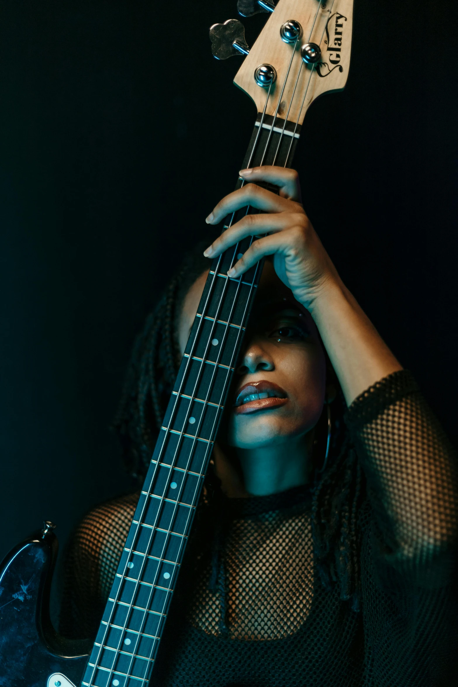 woman holding bass guitar with head held in her hands