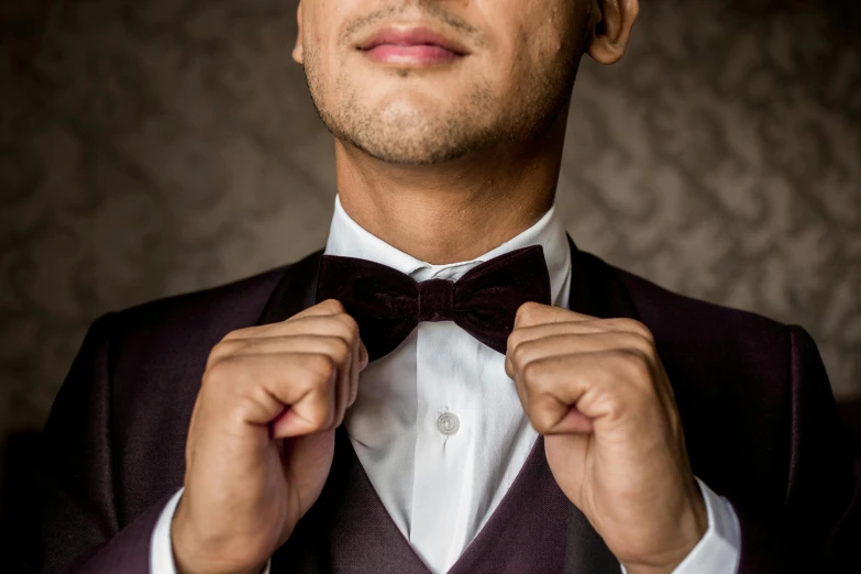 a close - up of a person adjusting his tie