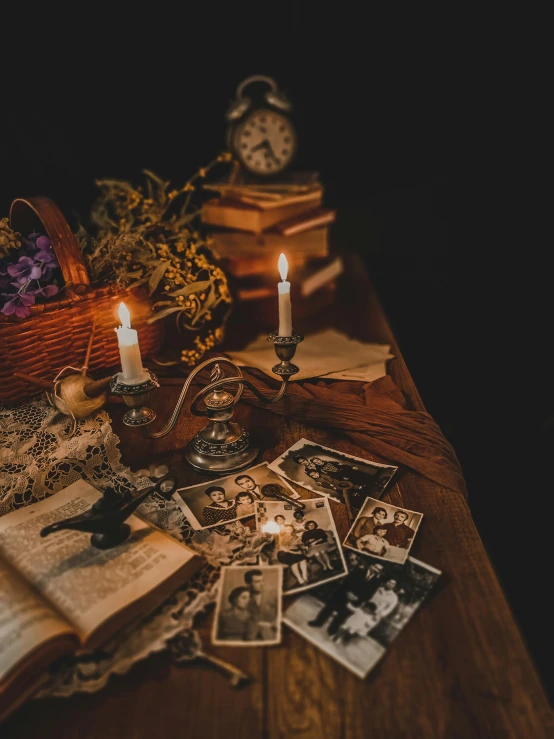 two candles, an old book, and other personal pos on a table