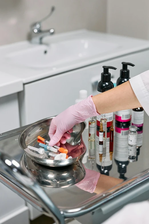 an ivist placing pills in the cup of a sink