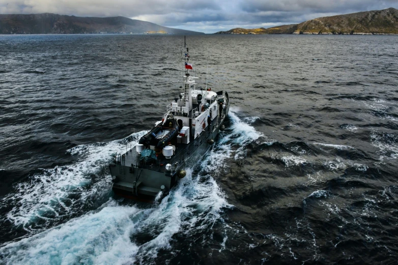 a ship traveling in the ocean under some dark clouds