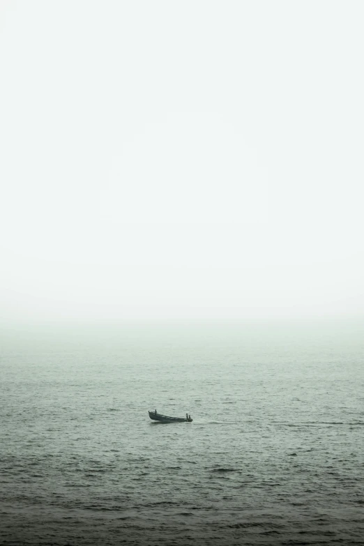 two people in a small boat floating on a large body of water