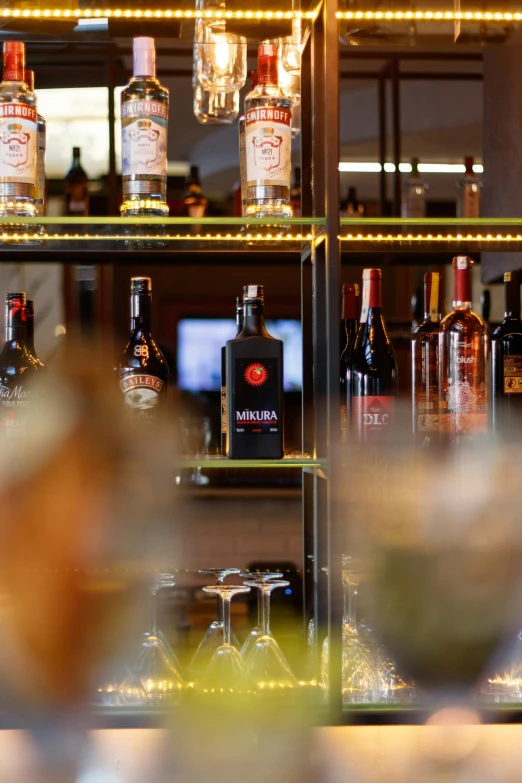 bottles of various liquor are in the window behind the bar