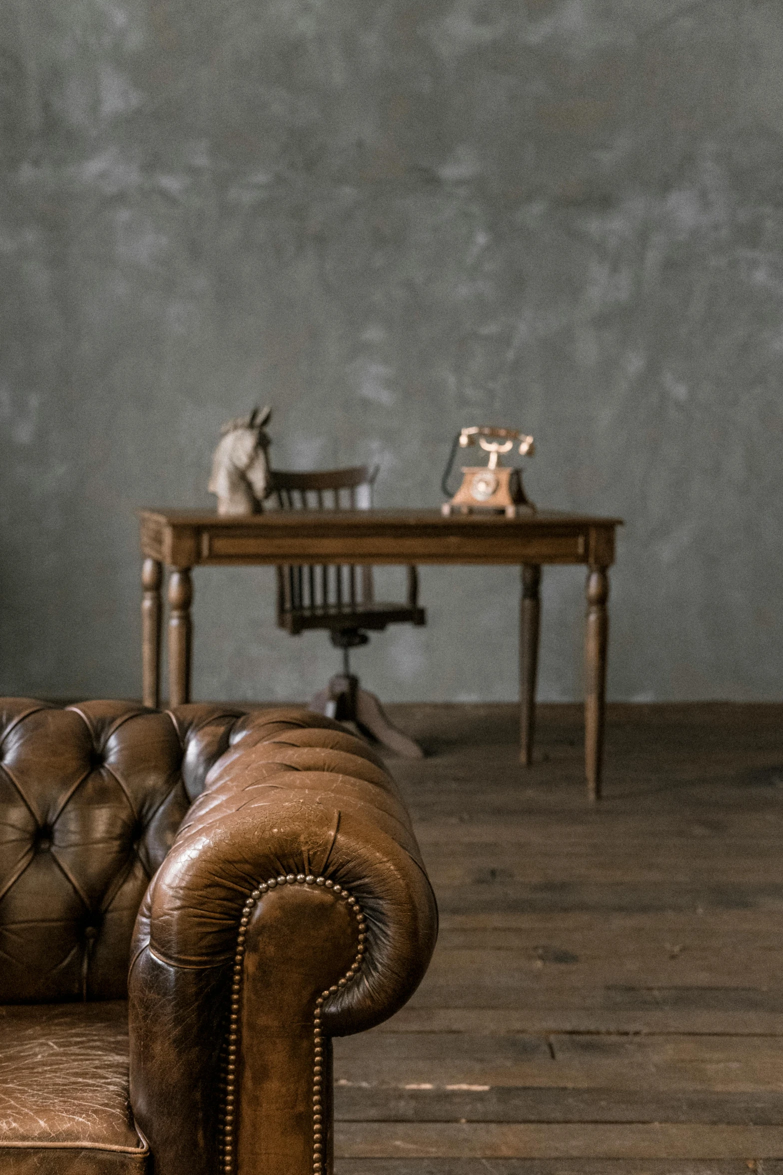 a large brown couch in the middle of a wood floor