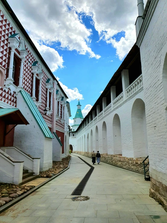 two people are walking down an empty walkway