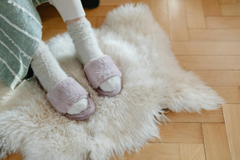 a person wearing pink and white shoes is standing on a furry rug