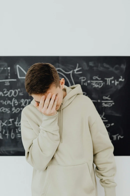 a man standing in front of a chalkboard covered with formulas