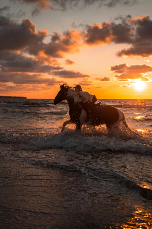two people on horseback are riding in the water