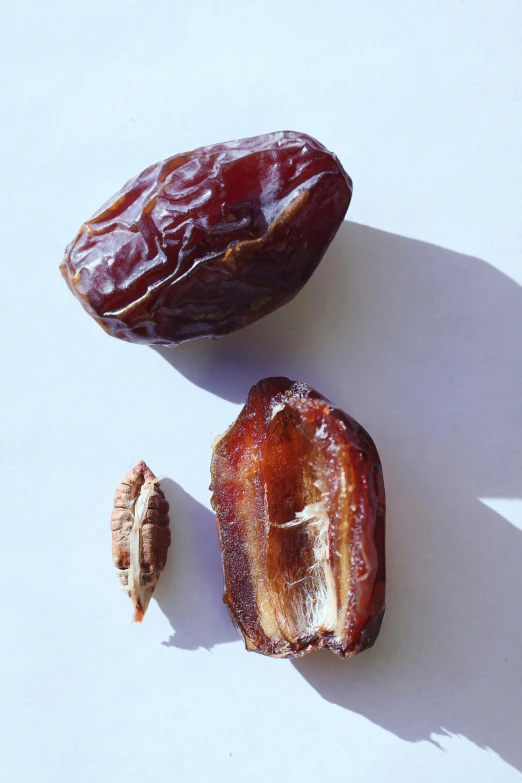 an almond and half eaten fruit on a white surface